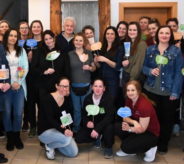 Eine Gruppe von Mitarbeitern posiert mit 30 Jahre-Jubiläumsschildchen