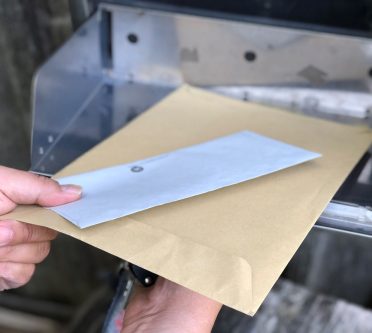 Briefe werden aus einem Briefkasten gezogen