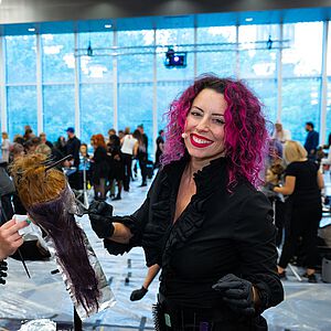 Mary Cromeans (rechts, mit pinken Locken) färbt mit einer Friseurkollegin Haare am Übungskopf